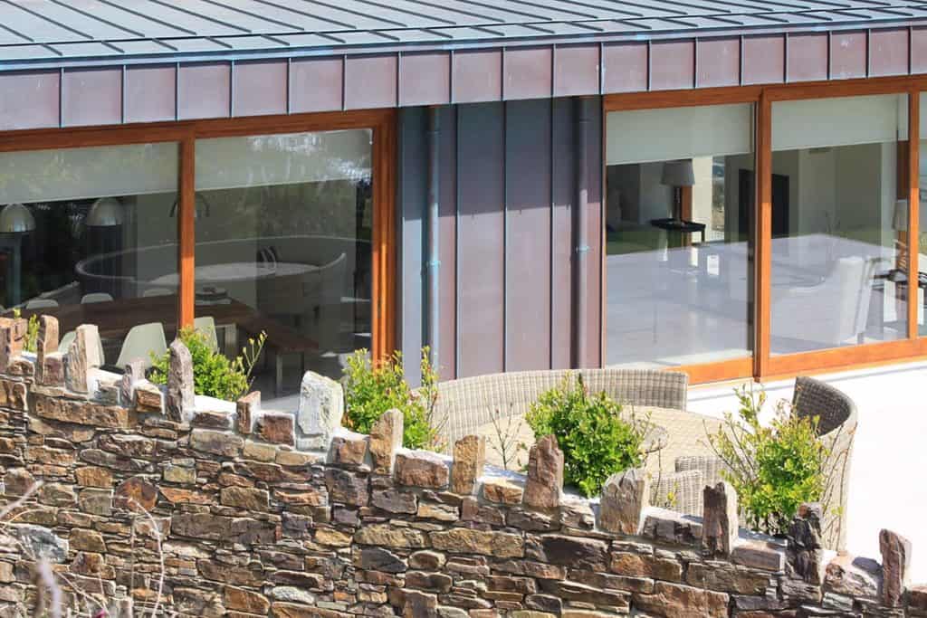 Close up of contemporary garden room with renovated stone wall