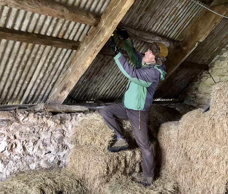 Richard Atkinson inspecting timber frame of old barn