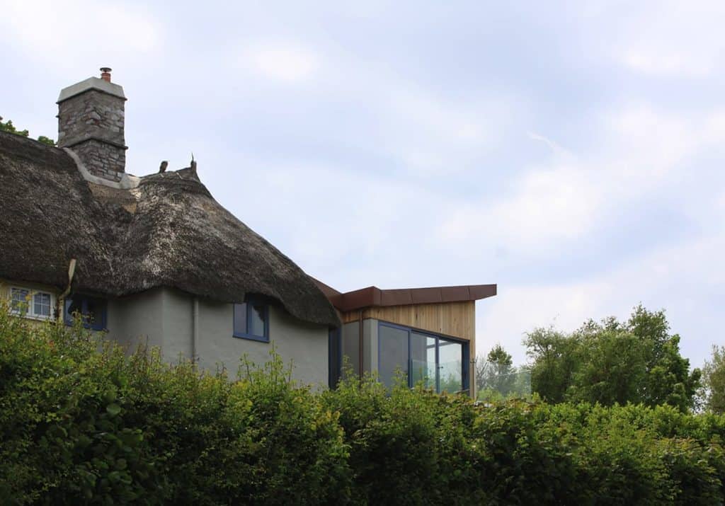 Contrasting architecture thatch and contemporary new build extension