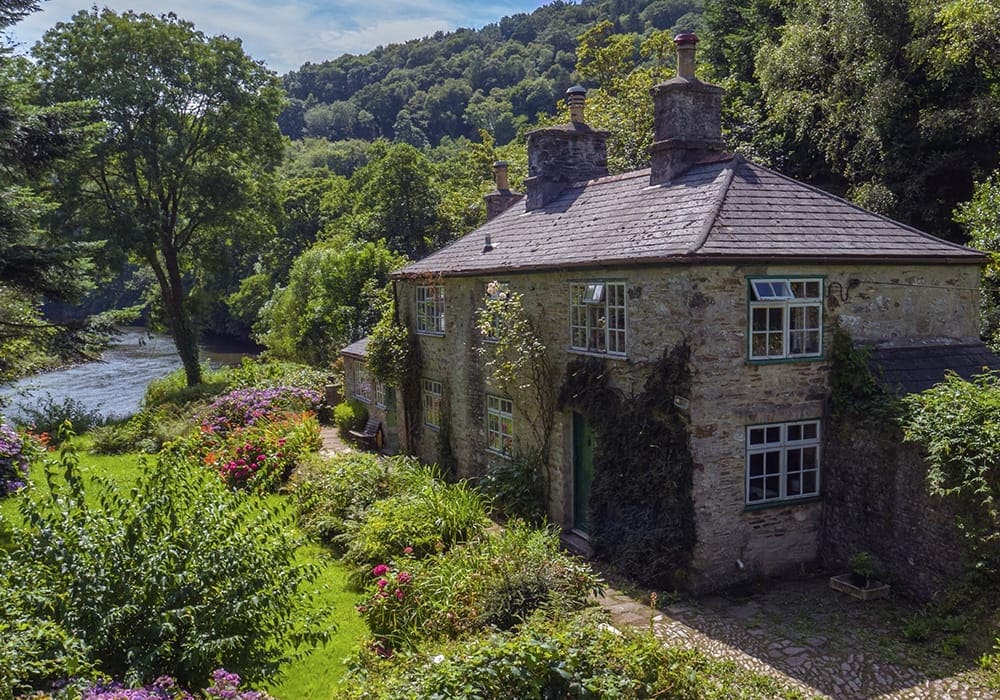 old cottage in a valley next to river