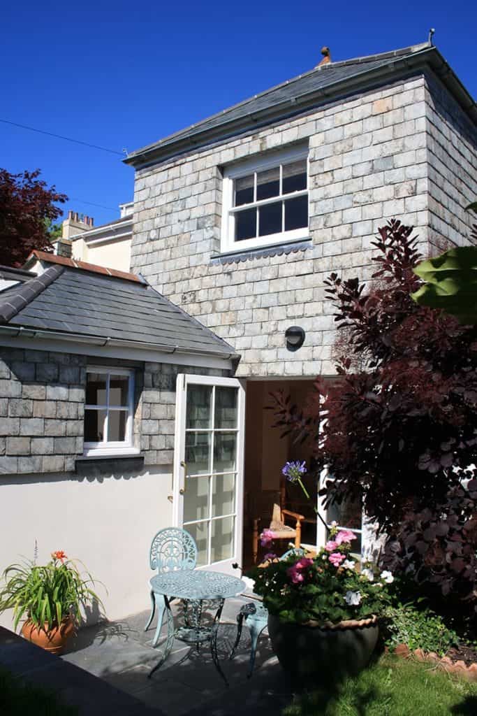 Delabole slates hanging on pediment of Georgian Townhouse with flower pots and red smoke plant